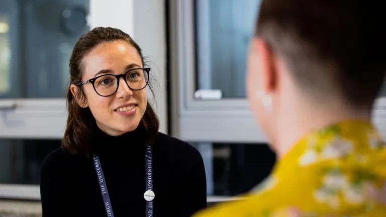 Member of staff listening to a student