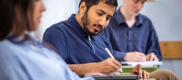 Student sat writing in a notepad