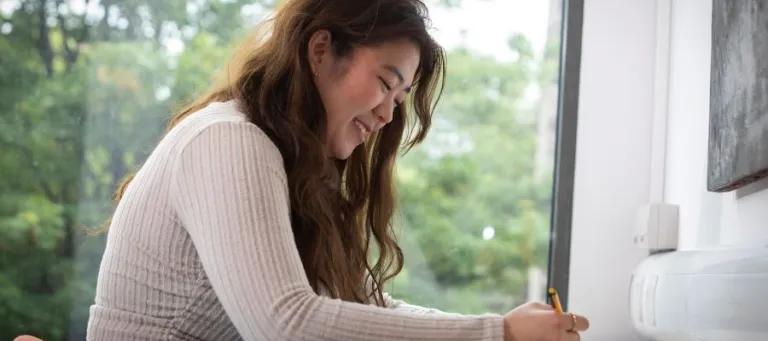 Student sat writing in a notepad