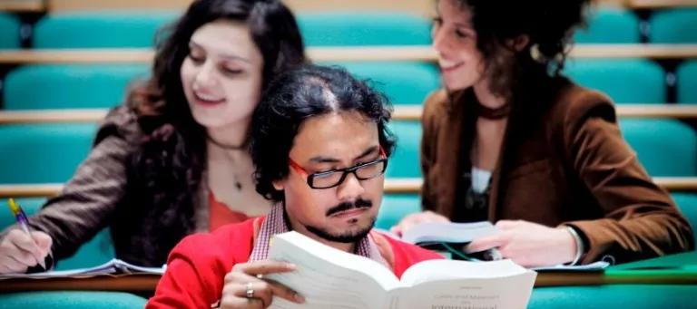 students sat with books in a lecture theatre